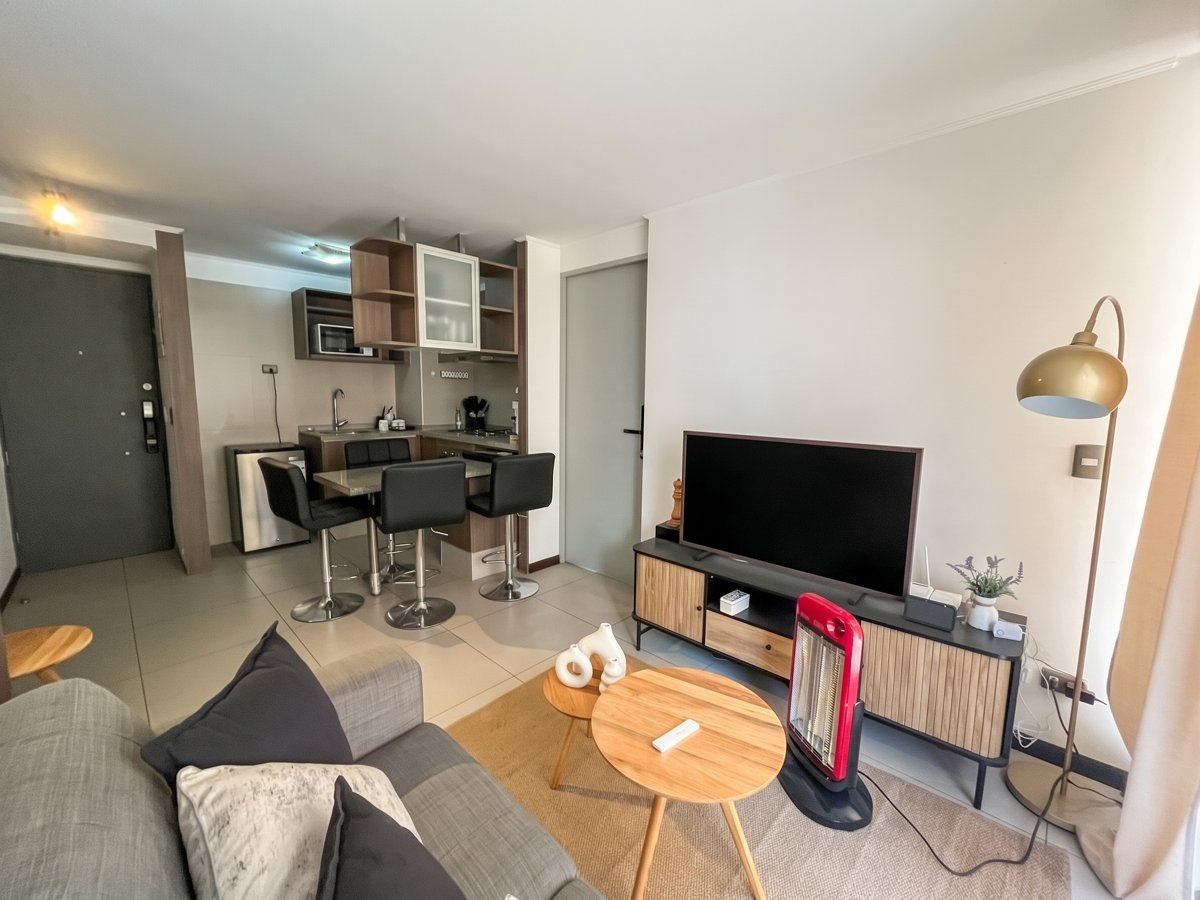 Living con sofá, televisor y comedor